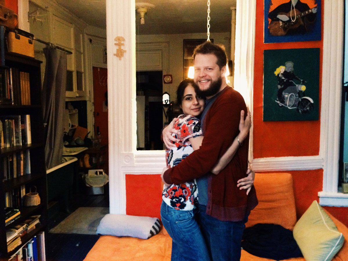 Photo of Mahira and John Paul hugging in the living room of the tenement apartment Mahira was renting.